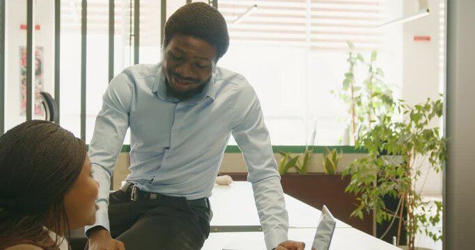Manager collaborates with employee at workspace using gentle mentorship