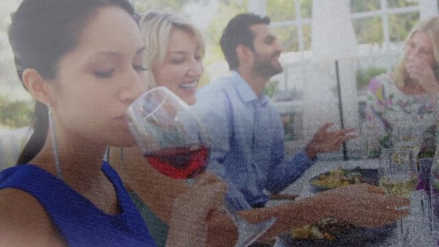 Woman in blue dress swirling tasting red-wine while reaching for whitewine prompted by dining chat