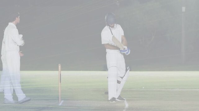Keeper clapping gesturing initiating batsman tapping adjusting pads preparing for ball under lights
