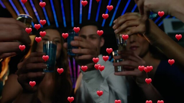 Vertical video: Smiling 5 friends toasting shots at bar, celebrating under LED hearts, light shirt