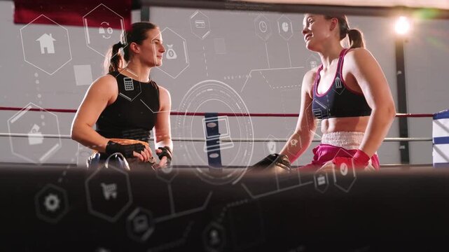 Two female boxing athletes after sparring, removing gear and debriefing while hex HUD showing stats