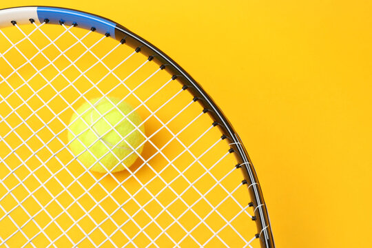 Large tennis court, balls and tennis racket on a yellow background