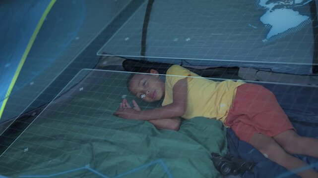 Camping light waking boy opening eyes, shifting on green bag, binoculars by legs, parent peering