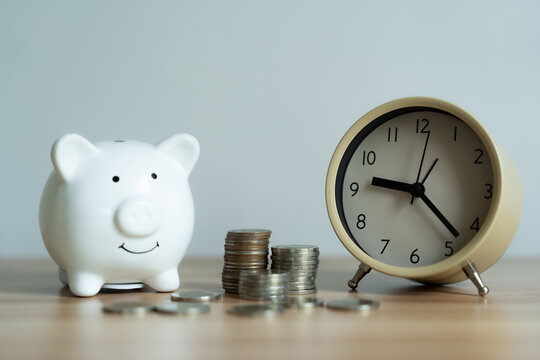 White piggy bank smiles gently beside coins. Vintage clock ticks past savings and time. Simple table holds quiet financial reminder. Perfect for budgeting, finance, or time management themes