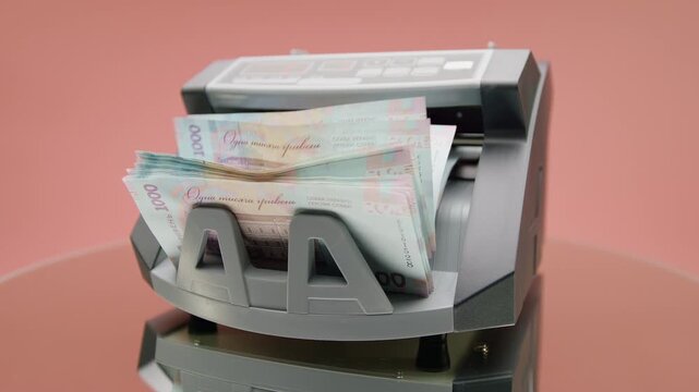 Ukrainian Hryvnia Bills In Money Counter on Pink
