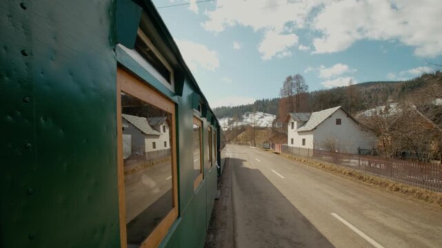 A steam train moves along the tracks in Bucovina, Romania, passing through villages and beautiful landscapes. Enjoy the sights of countryside and historic train.