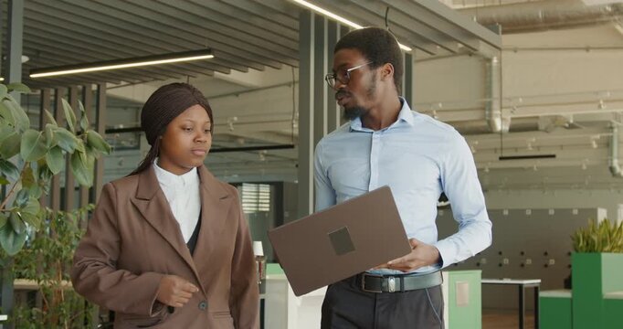 Black presenter delivering animated briefing to colleague