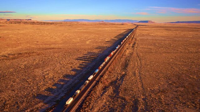 Drone footage freight train traveling across dry western plains, transportation, supply chain, industry concept
