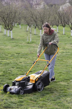 Woman Mowing Lawn in Rural Backyard &ndash; Countryside Living and Outdoor Chores Lifestyle