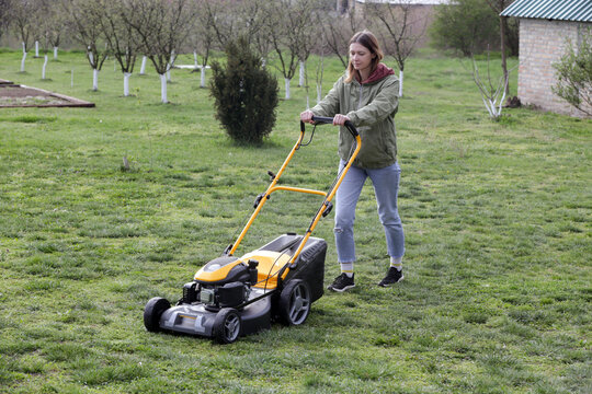 Woman Mowing Lawn in Rural Backyard &ndash; Countryside Living and Outdoor Chores Lifestyle