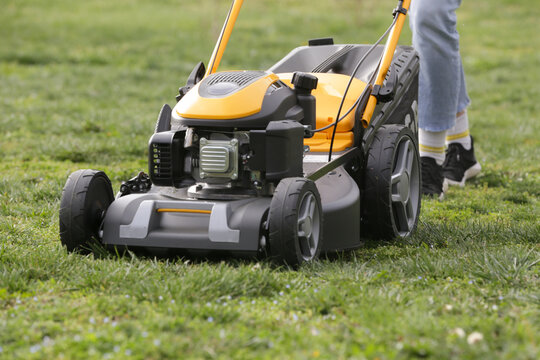 Woman Mowing Lawn in Rural Backyard &ndash; Countryside Living and Outdoor Chores Lifestyle