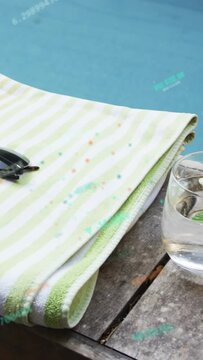 Vertical video: Cam moving right sends glass sliding, towel with shades centering to show pool calm