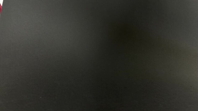 Fresh, ripe green apple gracefully rolls across a dark, minimalist surface in a captivating slow motion sequence, emphasizing healthy lifestyle choices and organic food