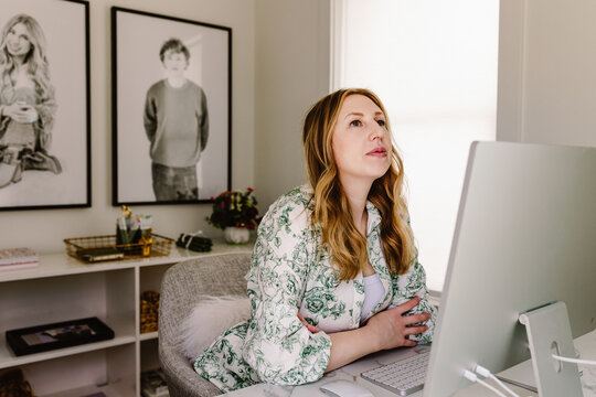 oman Woman working at home office desk with family photos