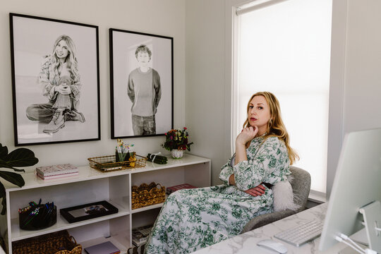 Middle aged woman posing in bright home office with decor
