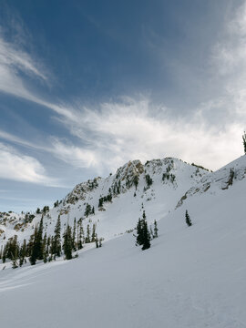 Snow-covered mountain slope beneath sweeping clouds