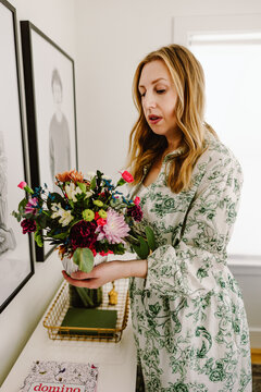 Woman arranging colorful bouquet indoors