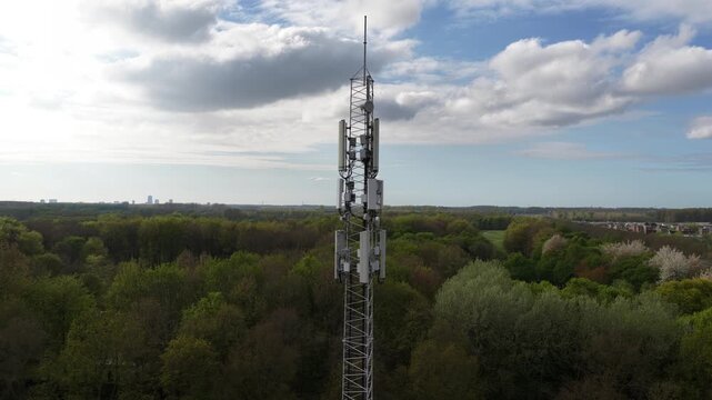 Telecommunication tower descending aerial view over forest