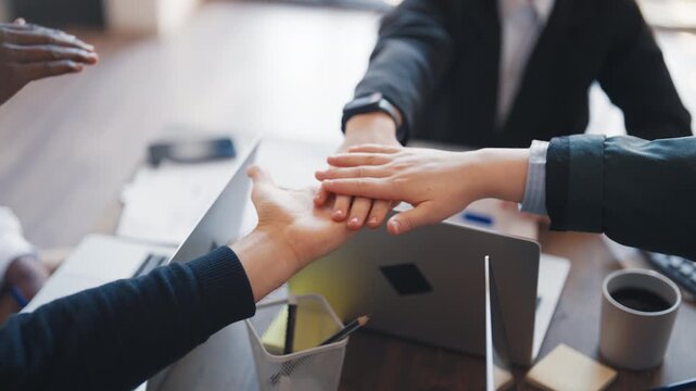 Diverse people connecting hands in office, closeup, gesture of partnership. Business meeting and co-working, team of partners making decision and moving to goal, unity and synergy, teamwork in office