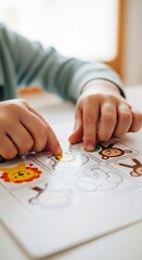 Fototapeta premium Young child interacts with a sticker activity sheet featuring various animal illustrations.