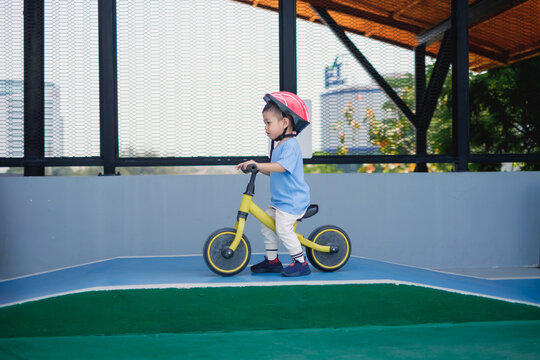Child riding balance bike at urban playground outdoor fun enthusiastic activity