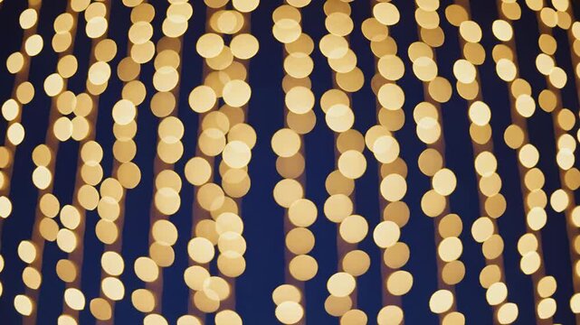 Abstract background of vertical golden bokeh light strings against a dark blue backdrop