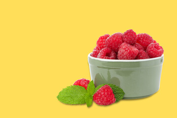 Bowl filled with fresh raspberries and mint leaves © Atlas