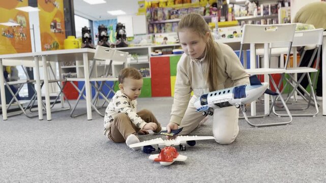 Children playing with toy airplanes in colorful playroom