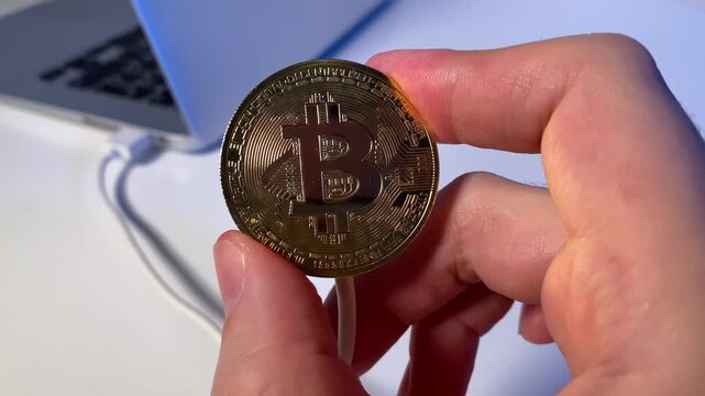 laptop and bitcoin. Coin in hand. Slow motion video.High quality 4K footage