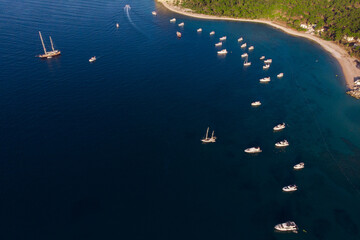 Aerial top view of luxury yachts and sailing boats anchored in a deep blue bay. Mediterranean sea resort, nautical transportation, summer vacation travel and coastal tourism business concept © GRON777