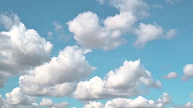 Time lapse fluffy clouds floating in a clear blue sky during the day. The varying perspectives highlight the different shapes and sizes of the clouds