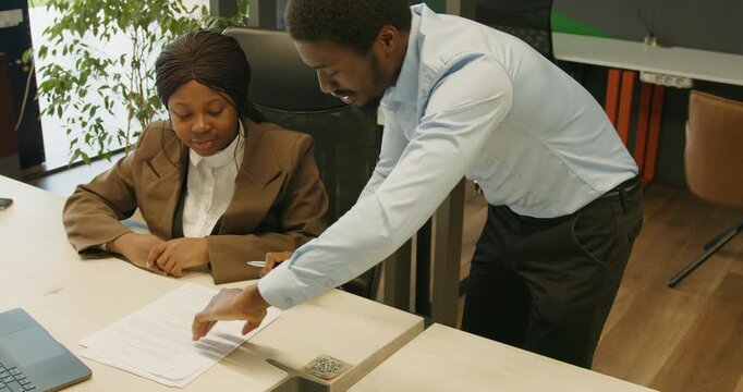 Finance officer explaining budget details to assistant