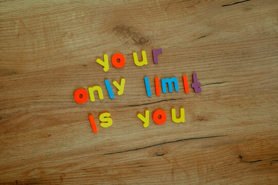 Colorful letters spelling a motivational quote on a wood background