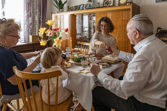 Multigenerational family celebrating Passover seder meal indoors