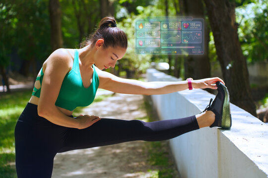 Woman stretching outdoors with futuristic fitness hologram