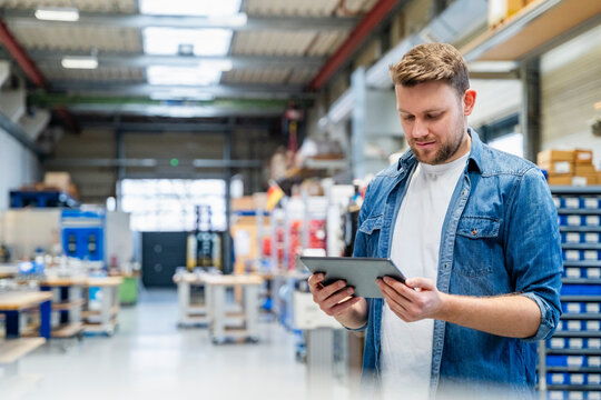 Manager using digital tablet in a production hall