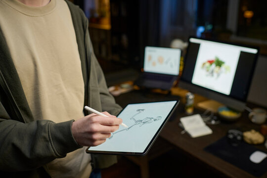 Digital artist drawing on a graphics tablet indoors at night