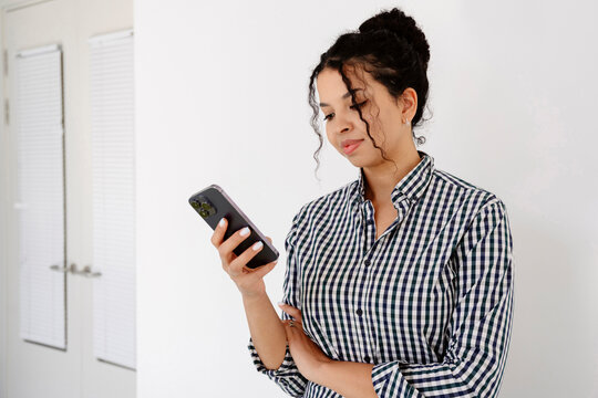Freelancer texting on smartphone indoors