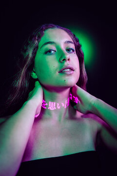 Neon portrait of teenage girl with pink glowing Japanese script on neck