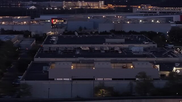Aerial view of data center campus in Ashburn Virginia USA at dusk with illuminated buildings, rooftop infrastructure and glowing lights highlighting cloud computing and digital network operations