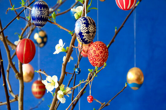Colorful homemade Easter eggs hanging on a wild quince branch