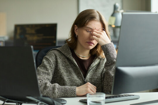 Tired programmer suffering from burnout at office computer