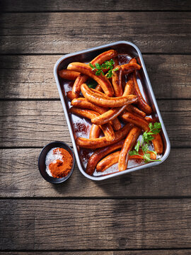 Roasted chili sausage in tray with spice on wooden table