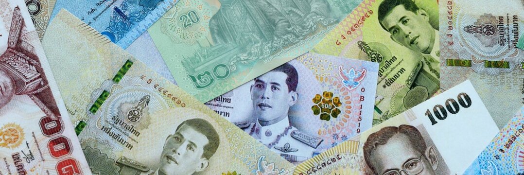 Thai baht money banknotes pile on table. Thailand bills of THB currency close up. Concept of economy