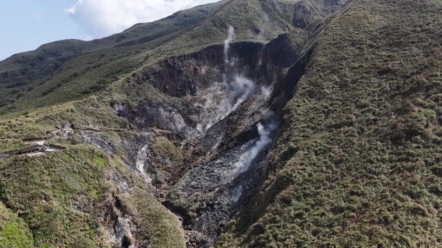 Geothermal fumaroles venting steam on volcanic mountain