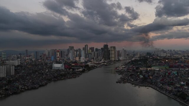 Dramatic aerial view of manila cityscape with pasig river at sunset
