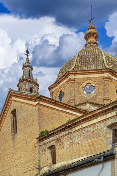 Dome of Santa Maria Church in Ecija, Spain, close up view. Traditional baroque architecture, ceramic tiles, cloudy sky