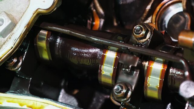 Operation of car engine camshaft in under hood compartment. Parts of mechanism move performing gas exchange for special system to operate