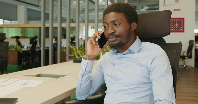 Employee in open workspace handling important phone conversation