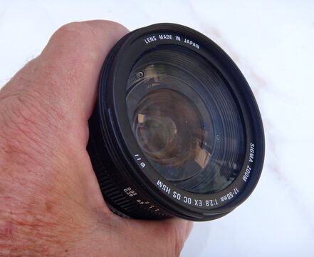 Hand holding Sigma zoom camera lens for photography
